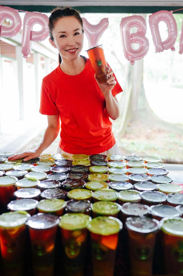 范文芳带儿子一起做公益，穿红T恤配白裤子，扎排骨辫清爽显年轻