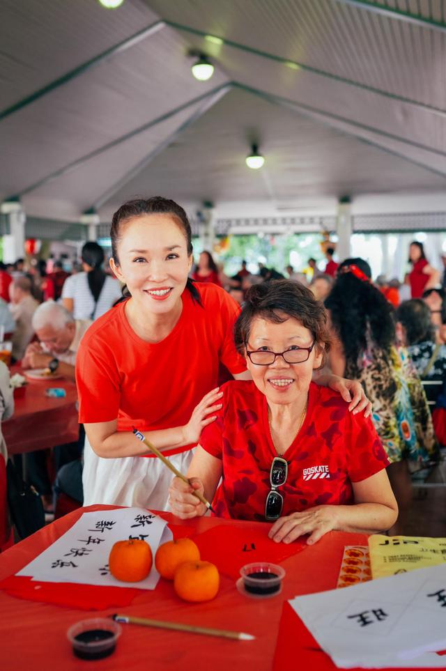 范文芳带儿子一起做公益，穿红T恤配白裤子，扎排骨辫清爽显年轻